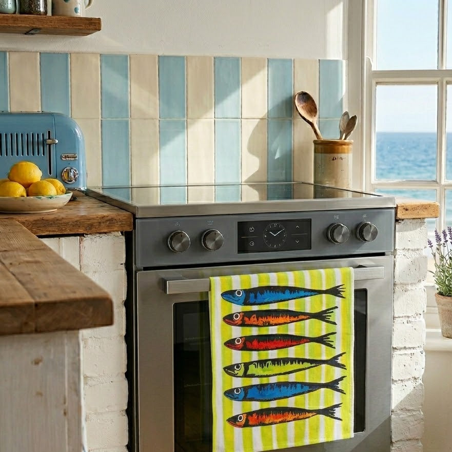 Kitchen with a stove and colorful fish towel, window overlooking water